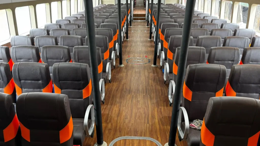 Modern seating arrangement and wooden flooring inside the passenger deck of dcamel fast boat alx.