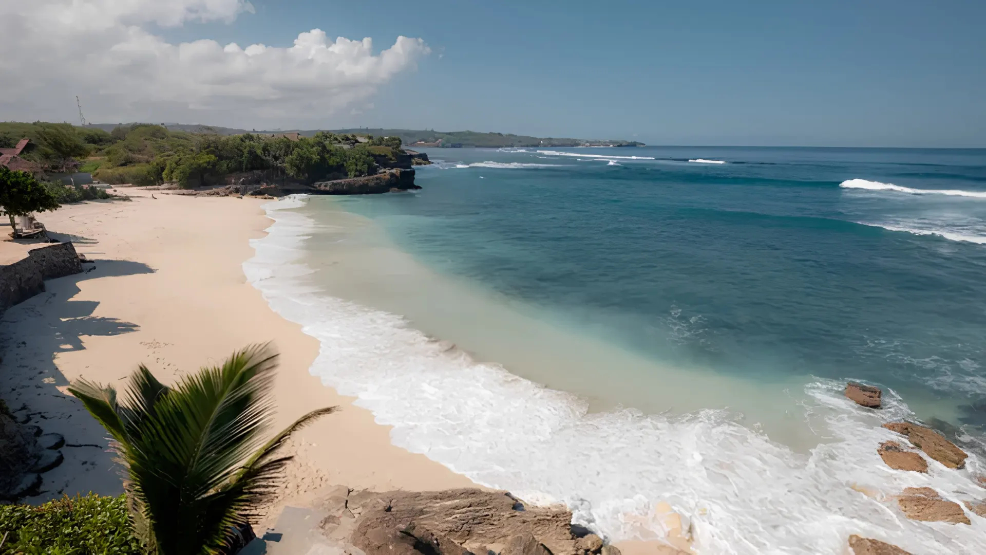 Gentle ocean waves crashing onto the quiet sandy shore of Dream Beach Nusa Lembongan under a clear blue sky.