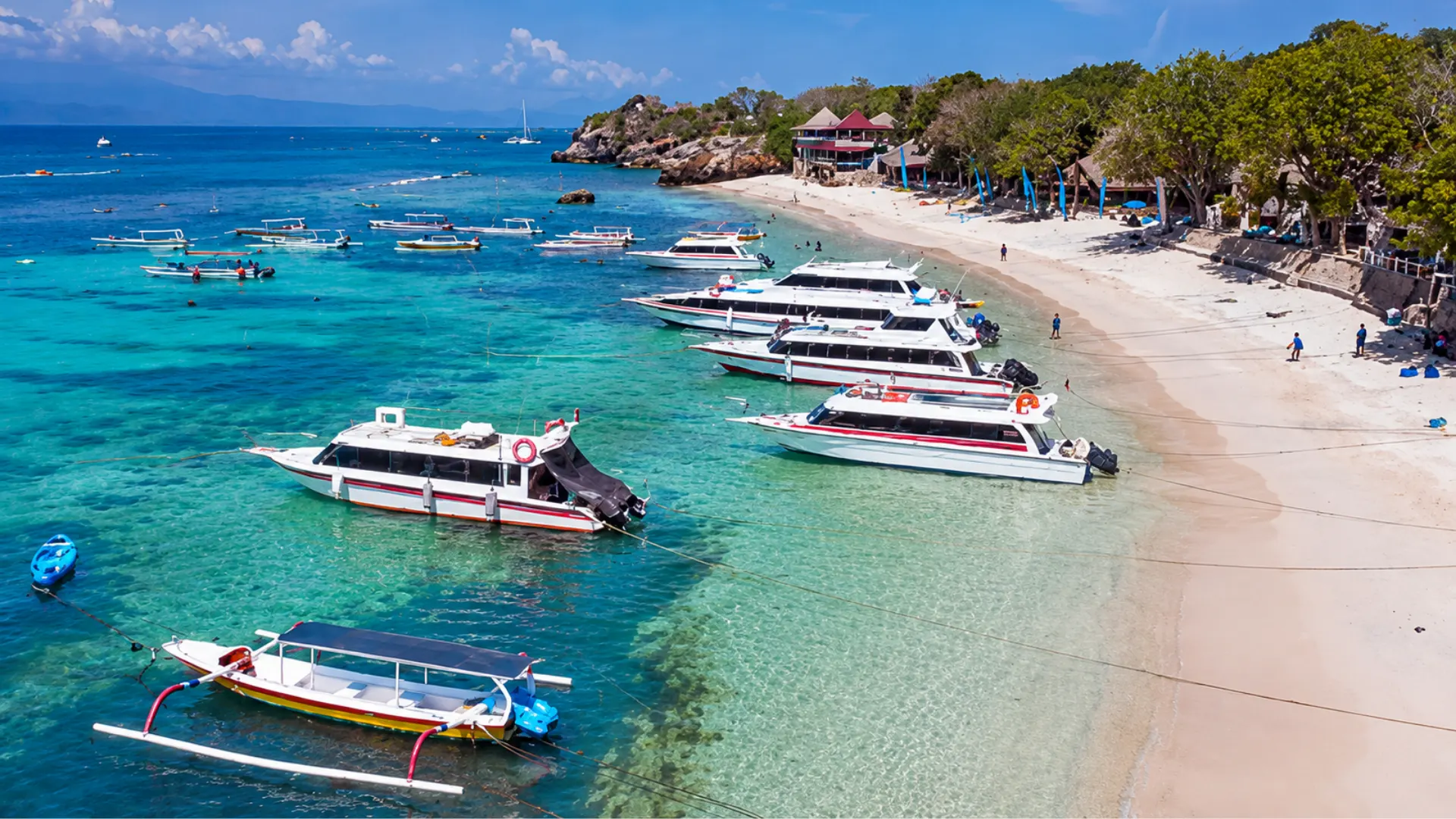 Leisure boats floating on the crystal-clear, calm tropical waters of Mushroom Bay Nusa Lembongan.