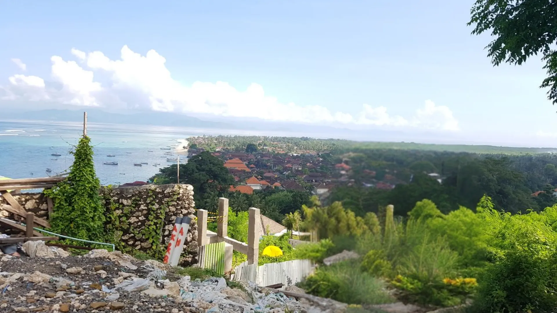 Elevated scenic viewpoint overlooking the coastal village and blue ocean bay from Panorama Point Nusa Lembongan.
