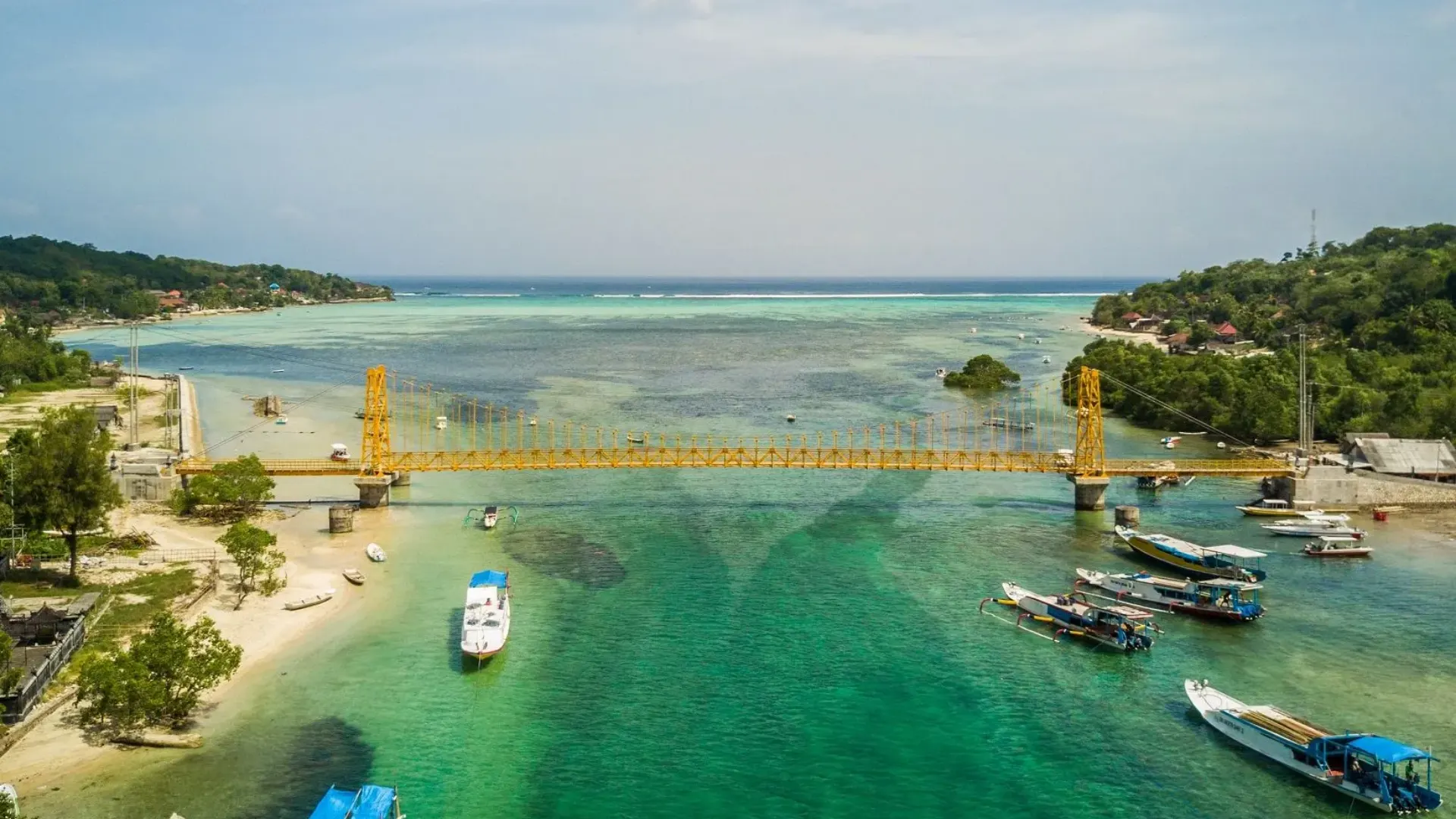 Panoramic view of the iconic Yellow Bridge Nusa Lembongan spanning across the narrow, clear ocean channel.